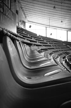 Monochrome image showcasing empty stadium seats creating a dramatic visual rhythm.