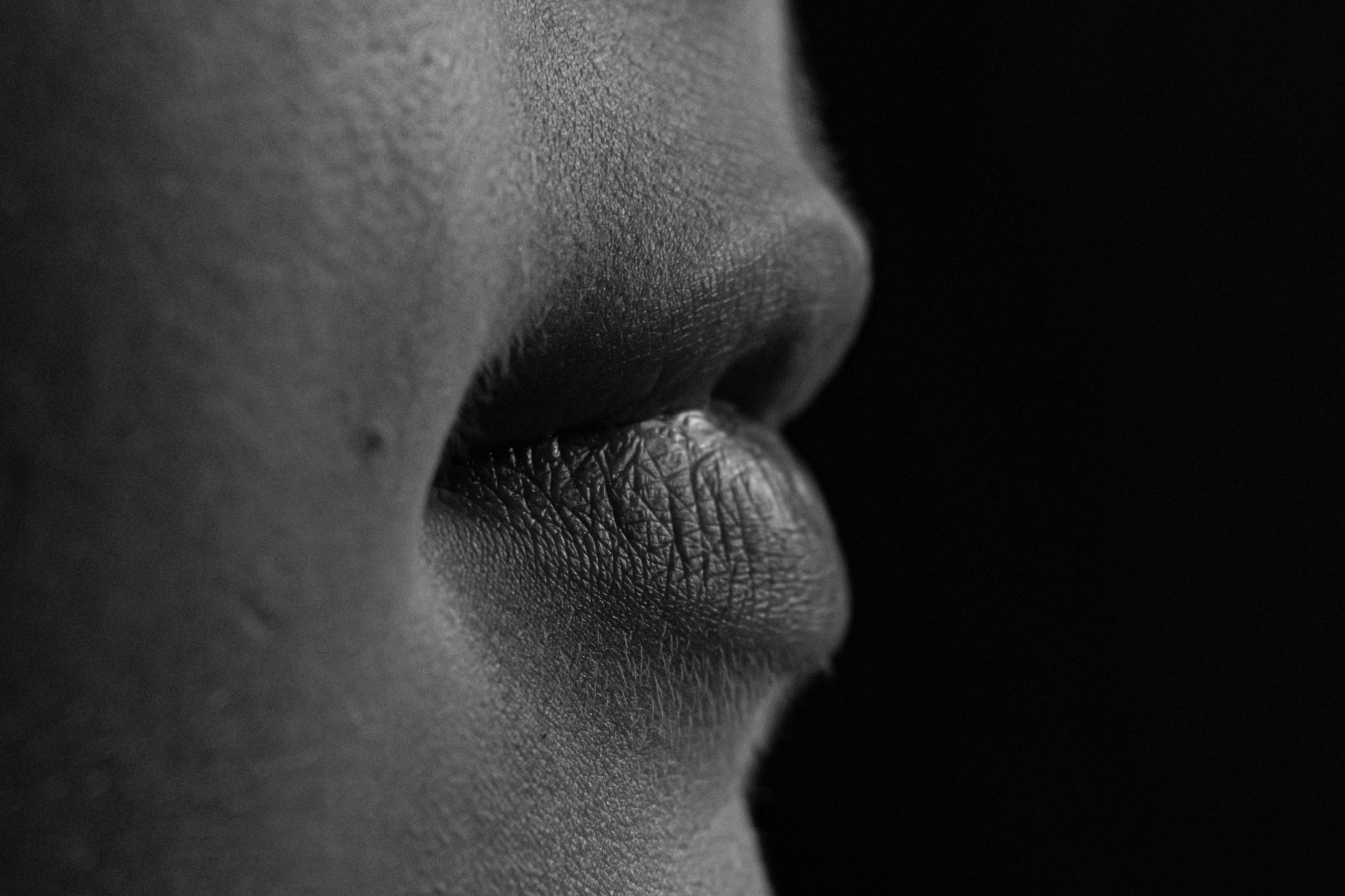 Black and white close-up of lips showing texture and details.