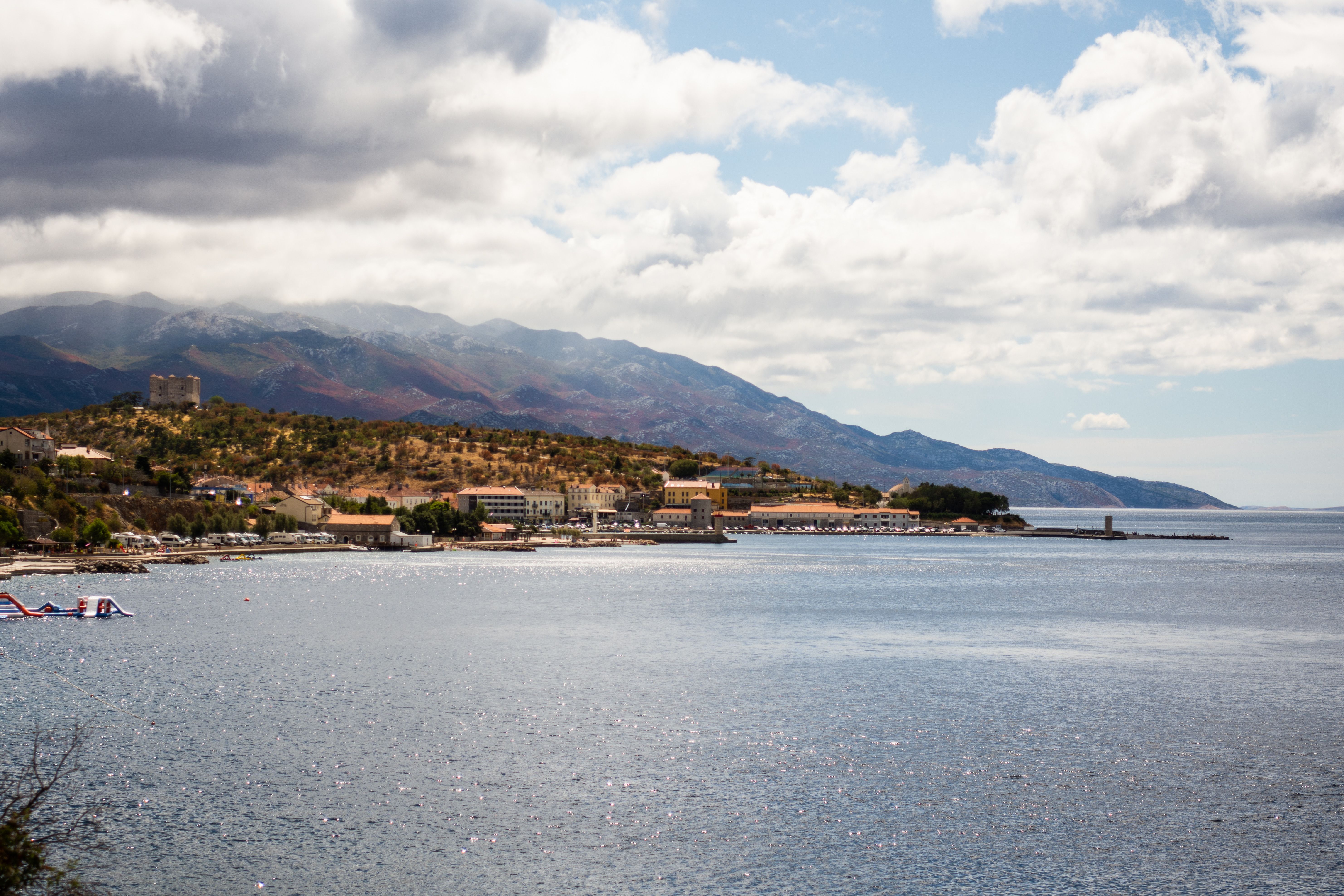 Stunning coastal landscape featuring mountains and a serene sea under a cloudy sky.