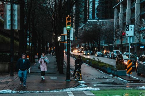 Free Urban street in winter with people walking and a cyclist, showcasing city life. Stock Photo