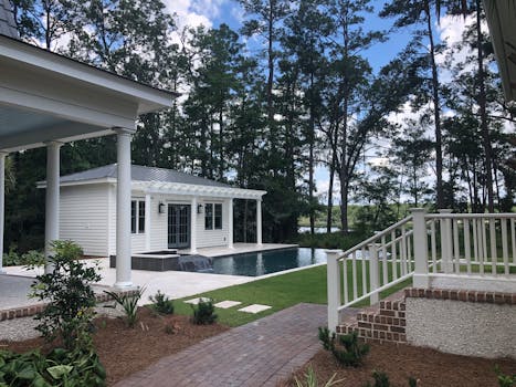 Explore a serene backyard with infinity pool surrounded by trees in Bluffton, SC. Perfect for relaxation.