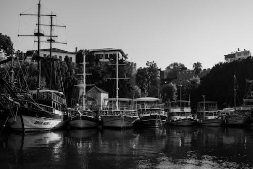 Grayscale Photo of Boats on Dock