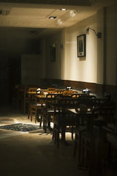 A warm, softly lit empty restaurant showcasing classic wooden furniture and intimate ambiance.