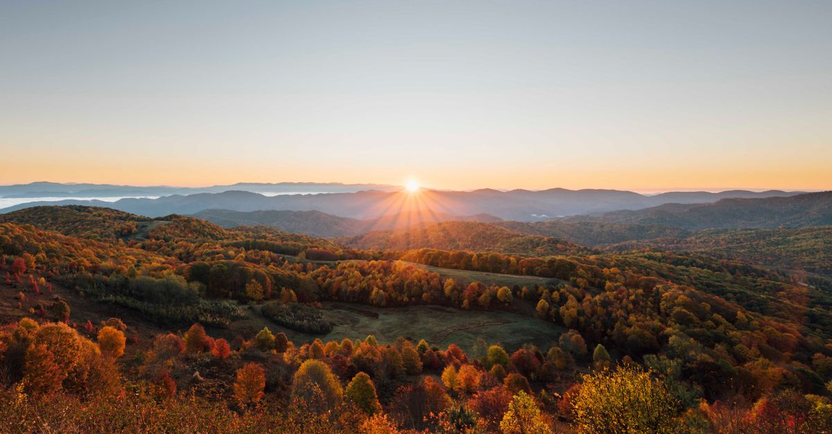 Breathtaking sunrise over autumn foliage in Hot Springs, NC mountains.