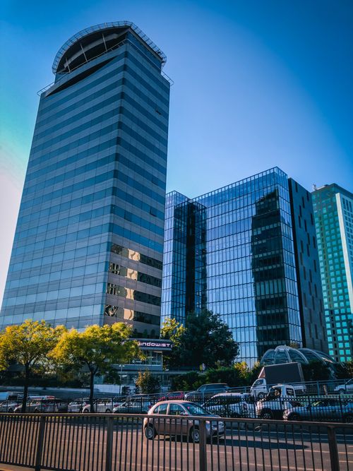 Free Dynamic cityscape featuring modern glass skyscrapers under clear blue sky. Stock Photo