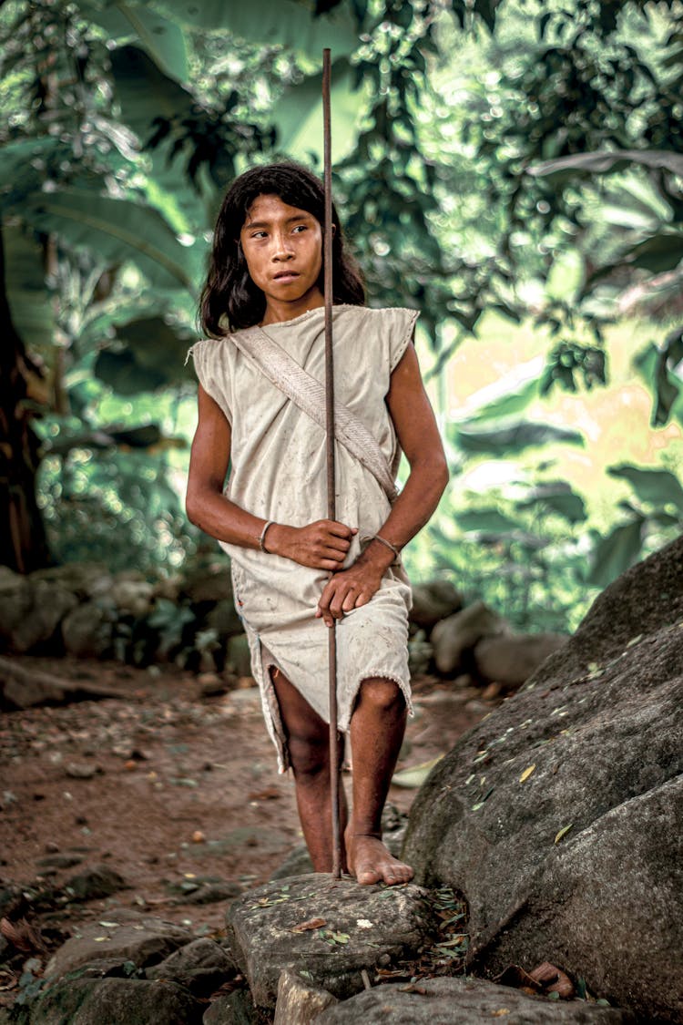 A Man In White Shirt Holding Brown Stick