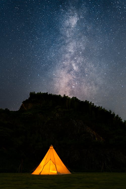 Illuminated Tent under a Starry Night Sky 
