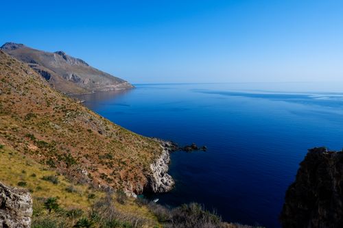 Free Breathtaking view of Scopello's coastline in Sicily featuring clear blue sea and rugged mountains. Stock Photo
