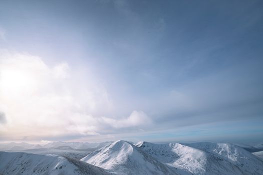 Breathtaking view of snow-covered mountains under a vast sky, capturing the calmness of winter.