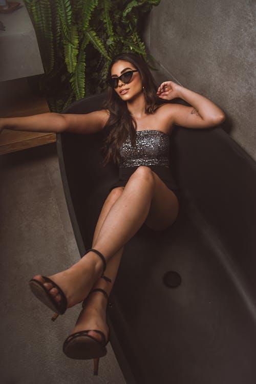 A Woman Sitting on Black Bathtub