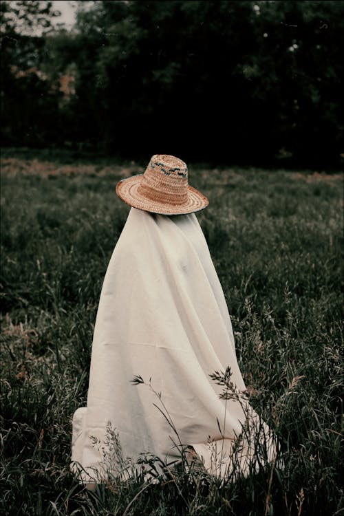 Person in White Robe Wearing Brown Straw Hat