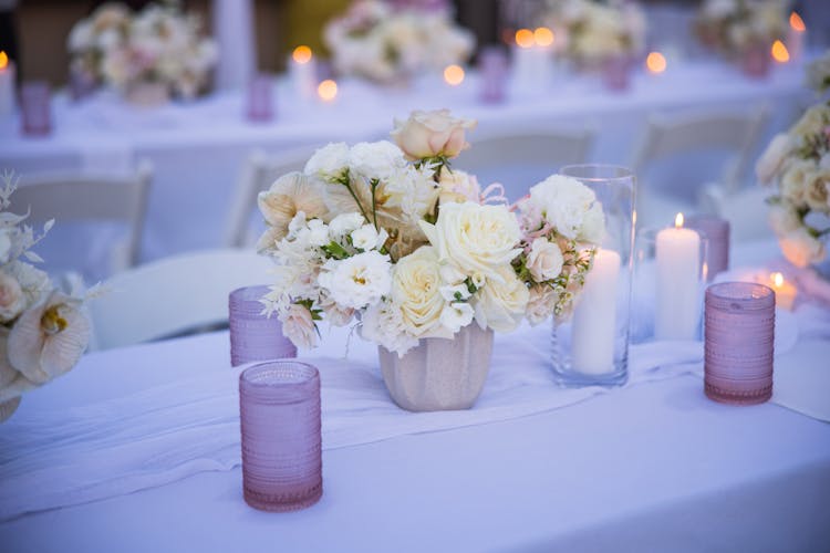 Flowers And Candles On Table Setting In Restaurant 