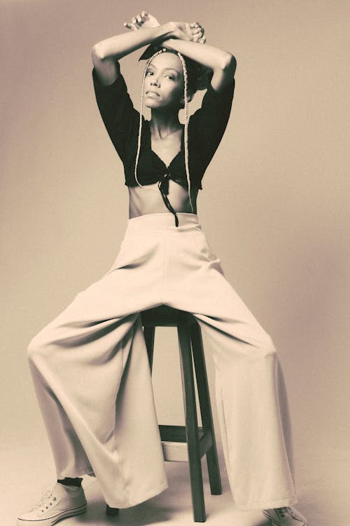 Sepia Tone Fashion Photography with Woman Wearing Loose Trousers Sitting on a Chair