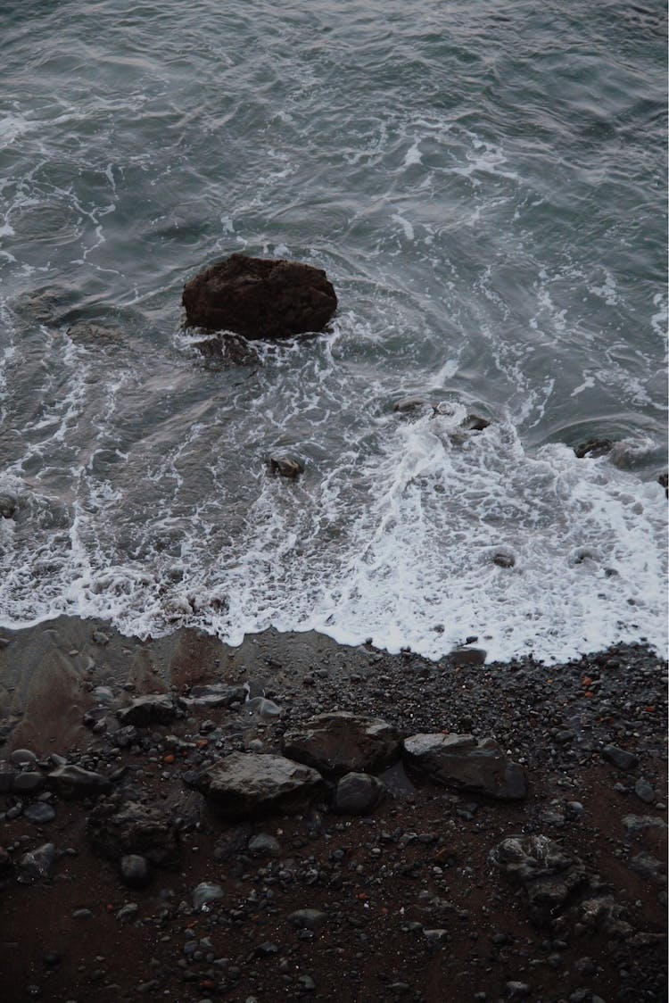 Waves Splashing On Shore With Stones