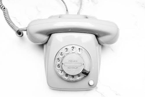 A Gray Rotary Phone on Marble Surface