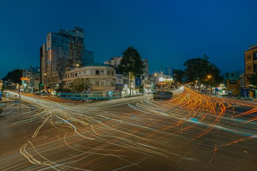 Dynamic long-exposure of bustling night traffic in Saigon's urban landscape.