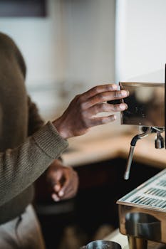 Close-up of a barista's hands using an espresso machine in a modern café setting.