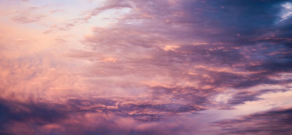 Serene sunset sky filled with pink and purple clouds, creating a dreamy atmosphere.