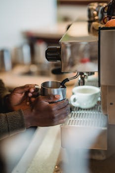 Man using an espresso machine to prepare coffee in a cozy café setting.