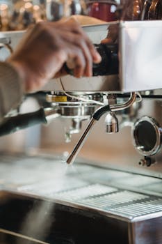 Close-up of a barista operating an espresso machine in a cozy café environment.