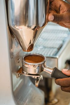 A detailed view of coffee preparation using a portafilter in a professional coffee machine.