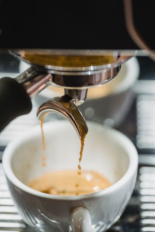 Free Detailed shot of espresso coffee dripping into a cup from a machine. Stock Photo