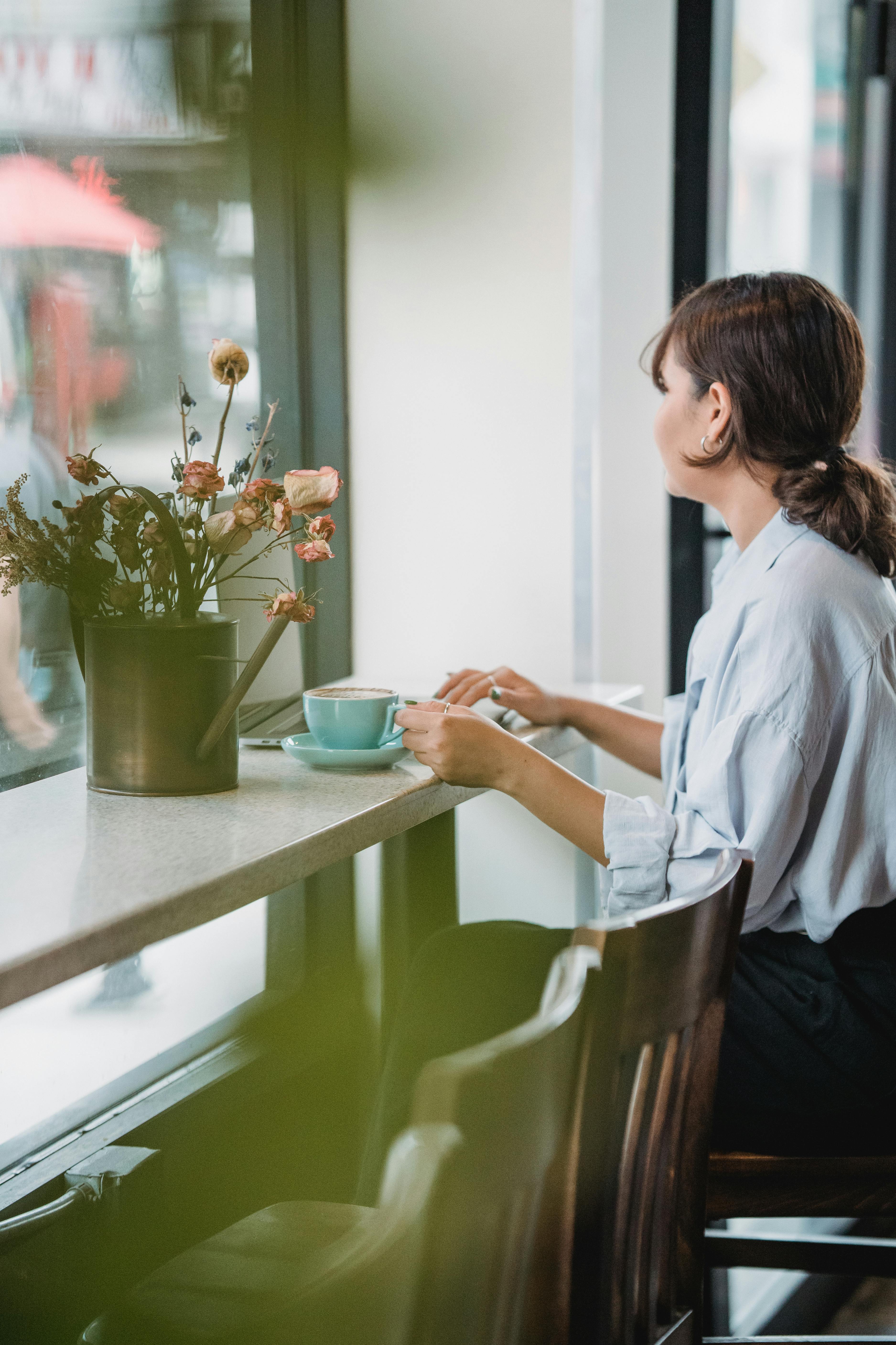 Solo Coffee Moments in a Cozy Café Brunette woman enjoying coffee alone in a cozy cafe