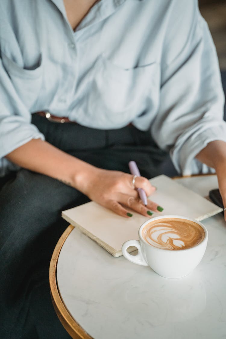 Woman Relaxing In Cafe With Coffee