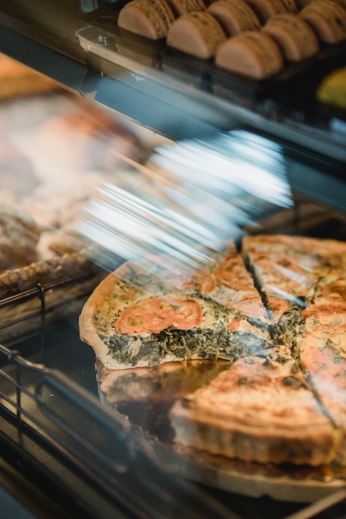 Free Freshly baked spinach tart in a bakery display, tempting and savory. Stock Photo