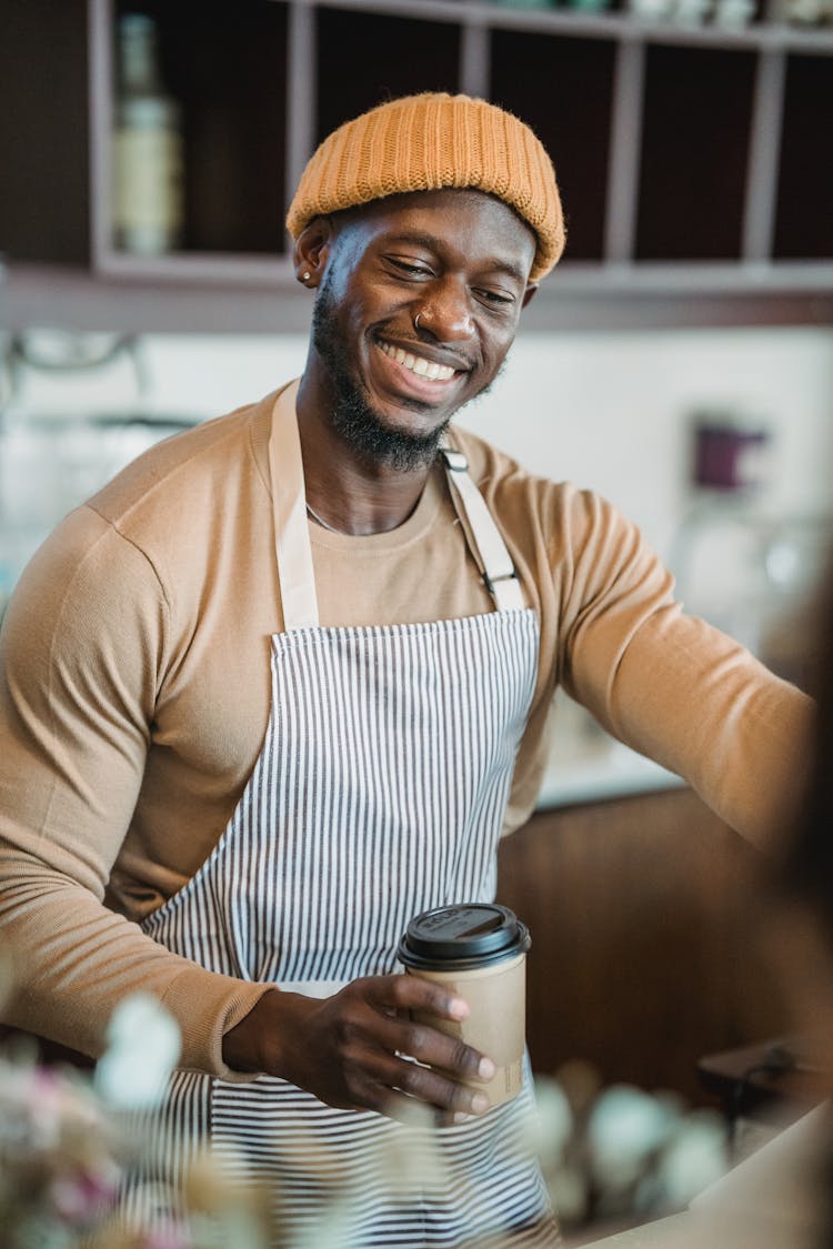 Barista In Cafe Wearing Apron And Hat