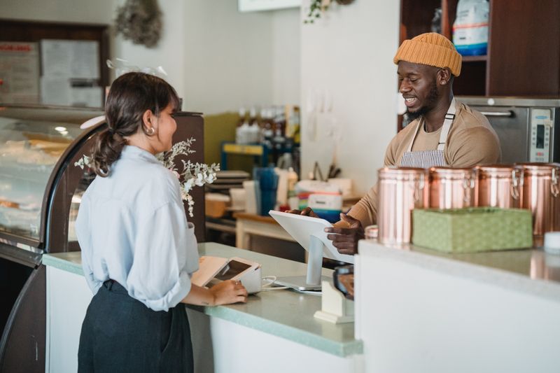 A customer being served at a cafe counter &mdash; photo by Mizuno K on Pexels