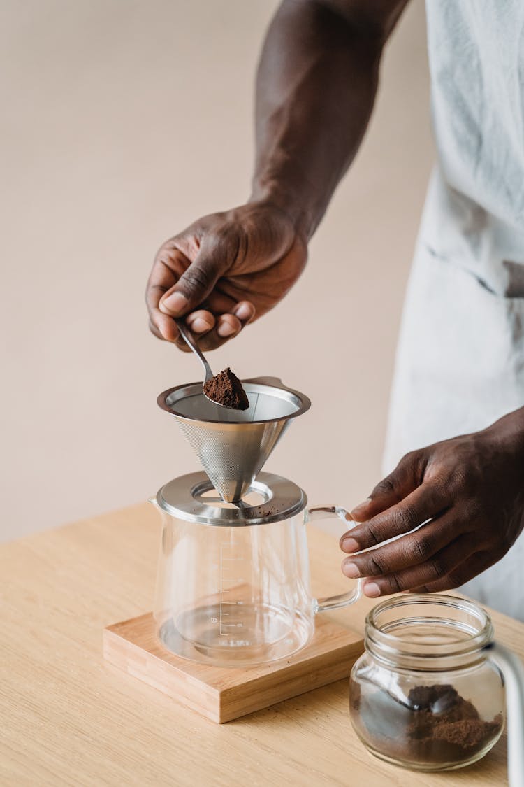 Man Sipping Coffee To Jar Through Sieve