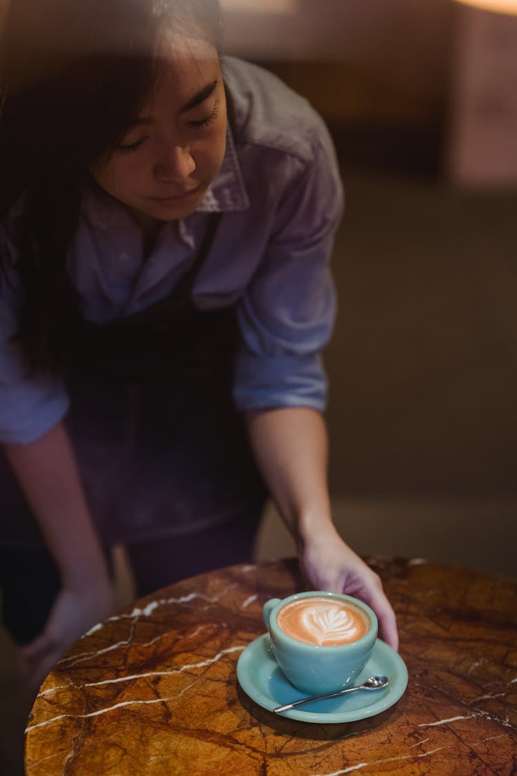 Woman Serving Coffee At Cafe