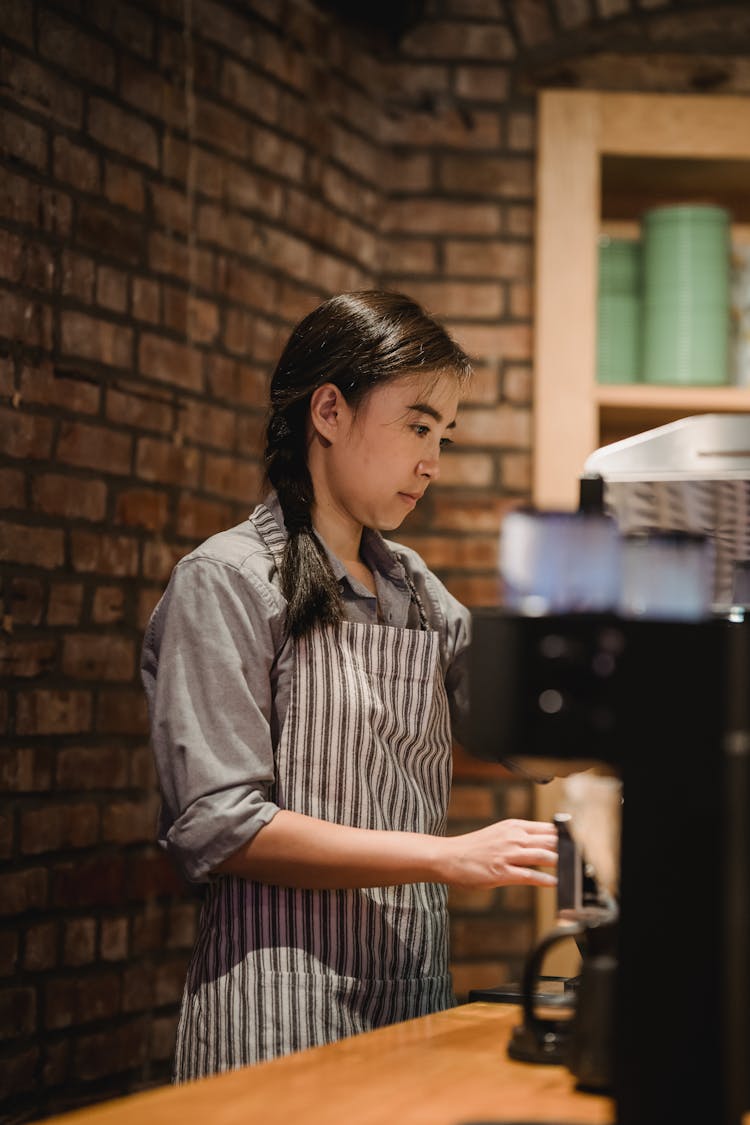 Woman In Apron Working At Cafe Counter