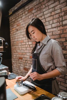 A focused barista preparing coffee with a portafilter at a stylish café with brick walls.