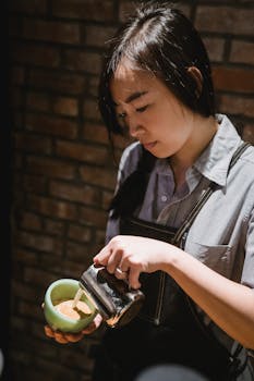 Barista focused on pouring milk into a coffee cup, showcasing her precision and artistry.