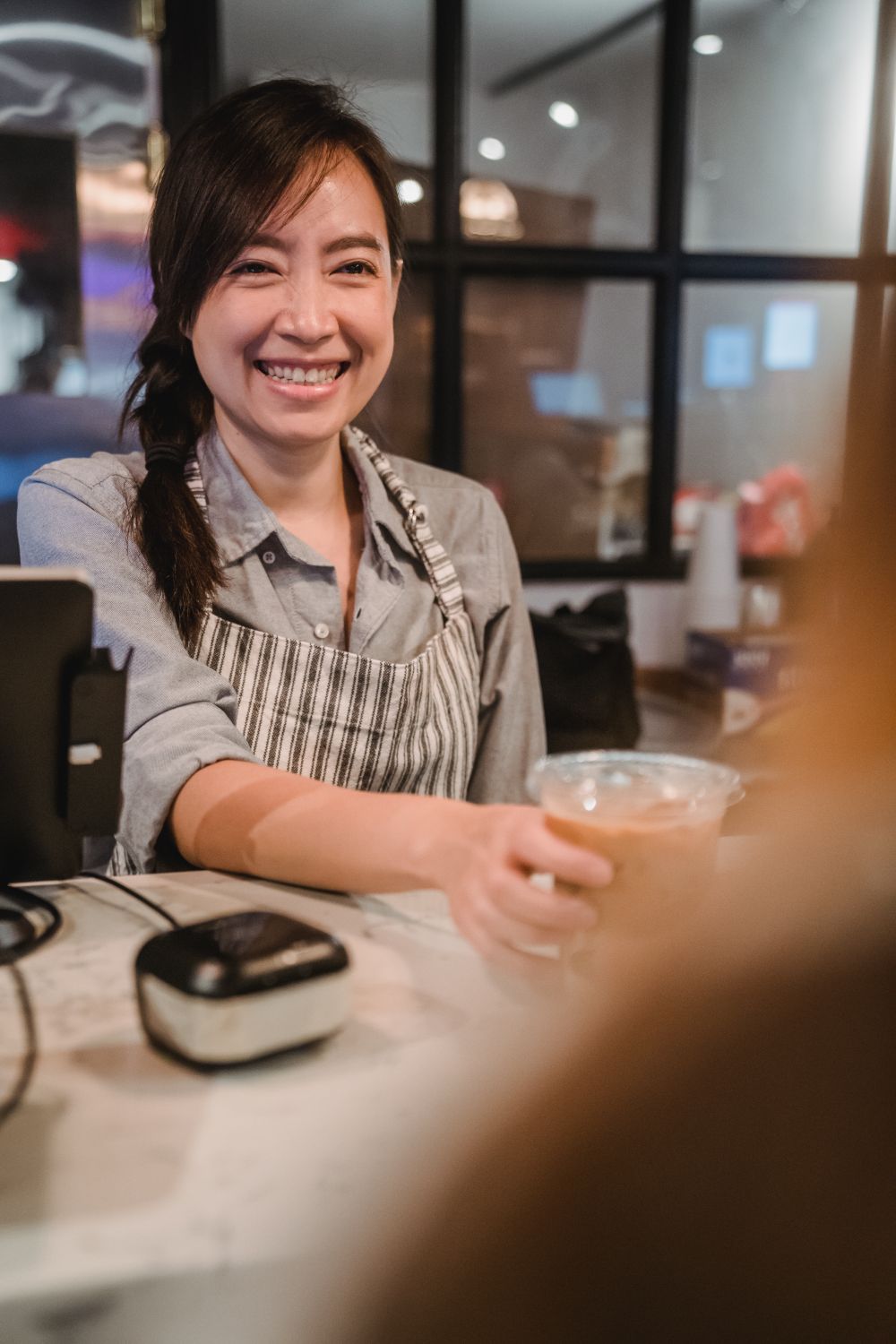 Profesional atendiendo con una sonrisa a una clienta
