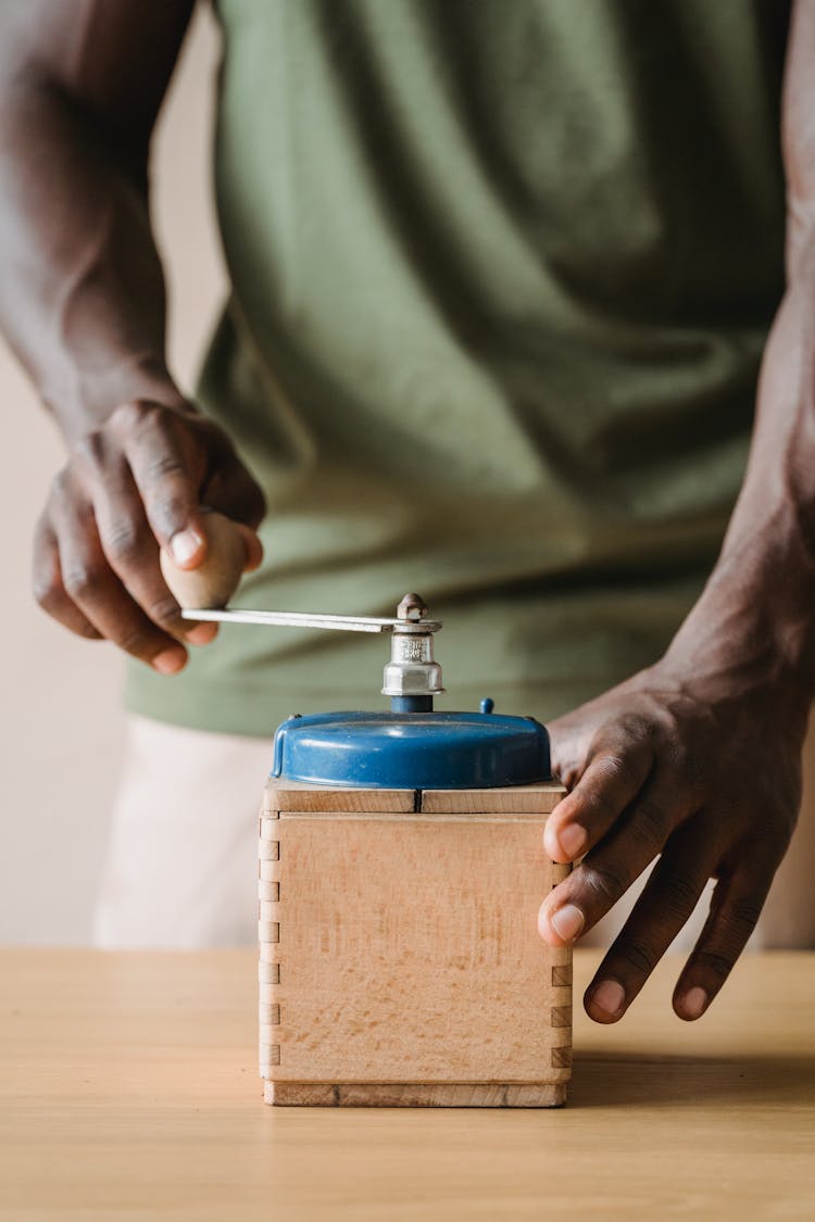 Man Using A Vintage Coffee Grinder 