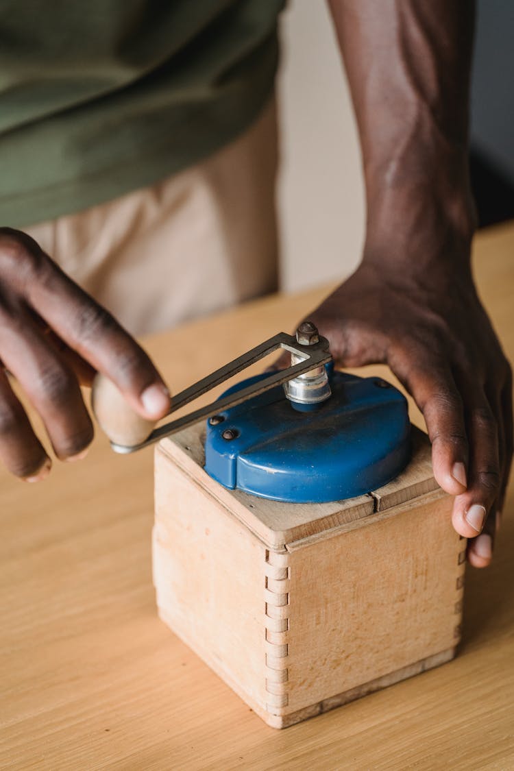 Man Using A Vintage Coffee Grinder 