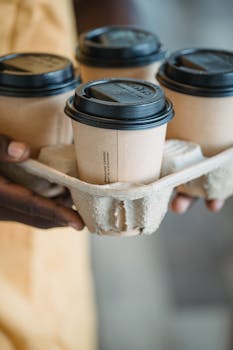 Close-up of four disposable coffee cups in a holder, perfect for on-the-go caffeine lovers.