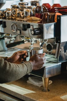 Barista preparing coffee with a professional espresso machine in a cozy café environment.