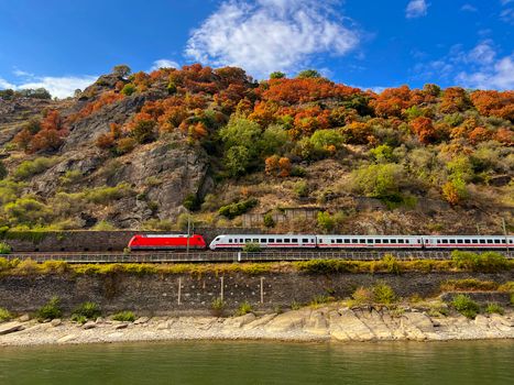 Train travels through Oberwesel's autumn landscape along the Rhine River.