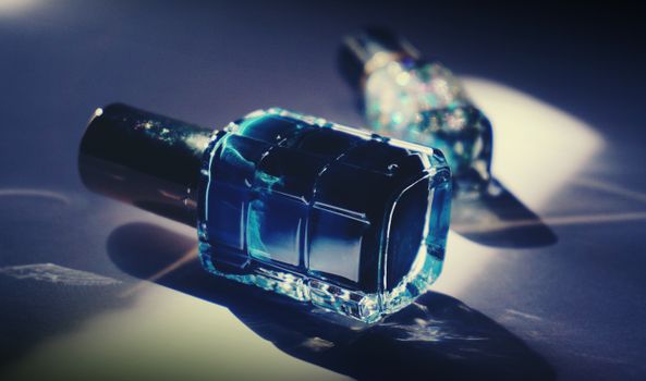 特写镜头中，豪华蓝色指甲油瓶投射出倒影