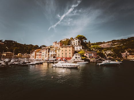 Picturesque view of Portofino harbor with anchored yachts and colorful hillside buildings.