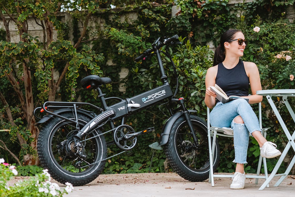 Free A Woman Sitting beside an Electric Bike Stock Photo