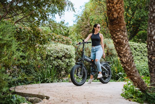 Woman in Black Tank Top with Sunglasses Riding on an Electric Bike
