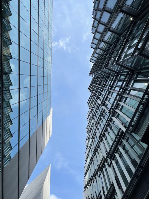 Free Low angle view of modern skyscrapers in London, capturing urban architecture against a blue sky. Stock Photo