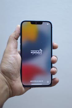 Close-up of a hand holding a smartphone displaying the greeting 'Namaste'.