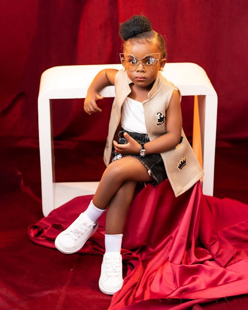 Little Girl Wearing a Vest Sitting in a Studio