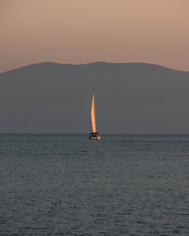 Sail Boat On A Lake And Mountain At Dusk